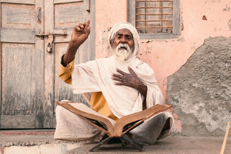 Old indian sadhu speak up sacred scriptures.
