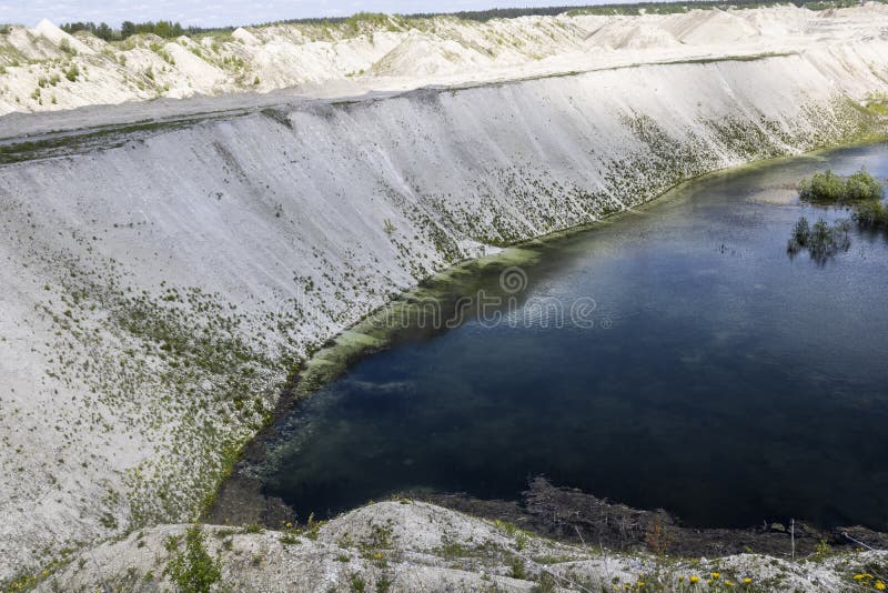 Old Industrial Chalk Quarry with Water Overgrown with Algae and Mud