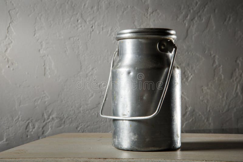 Old kind of aluminum bidon for milk storage stands on kitchen table. Traditional big metal pot stock images, royalty-free photos and pictures