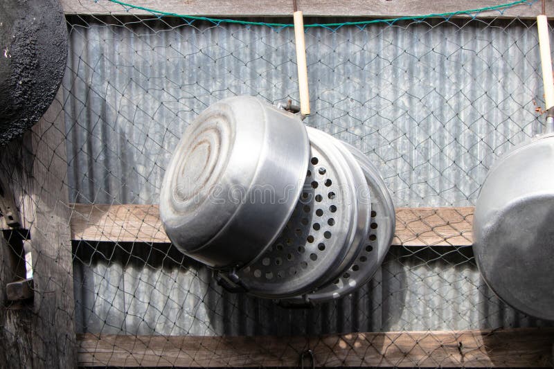 Old Kitchenware Various Sized Metal Pan Pot Hanging in Row on Hooks