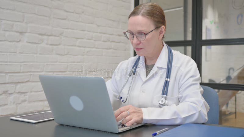 Old Lady Doctor Typing on Laptop in Office stock video