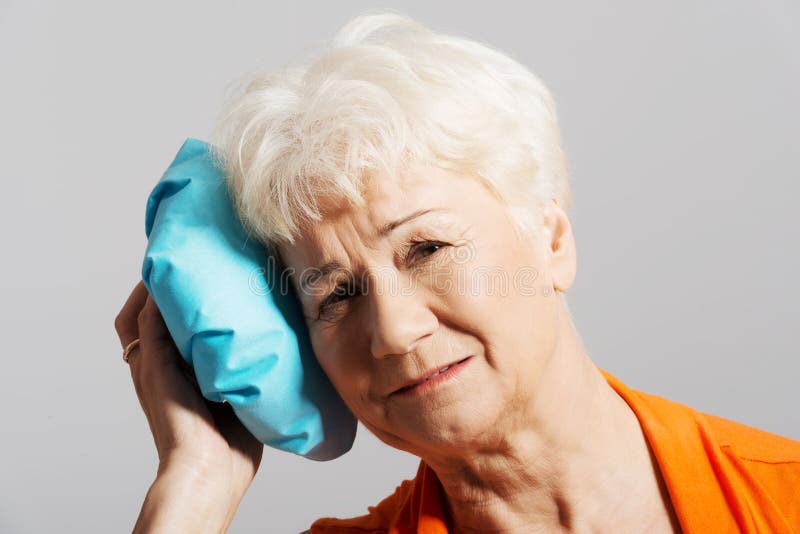 An old lady with ice bag by her head. stock image An old lady with ice bag by her head. stock image