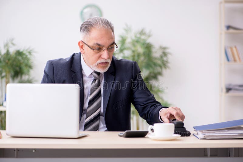Old male boss employee working during pandemic stock photography