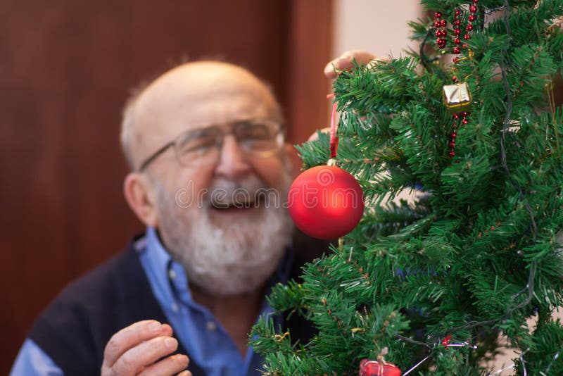 Old man by the Christmas tree