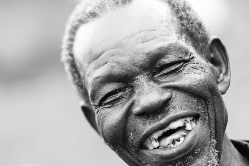 An old man laughing with no teeth.