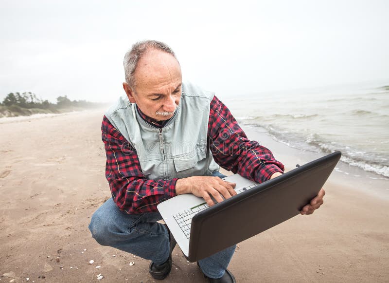 Old man with notebook on beach