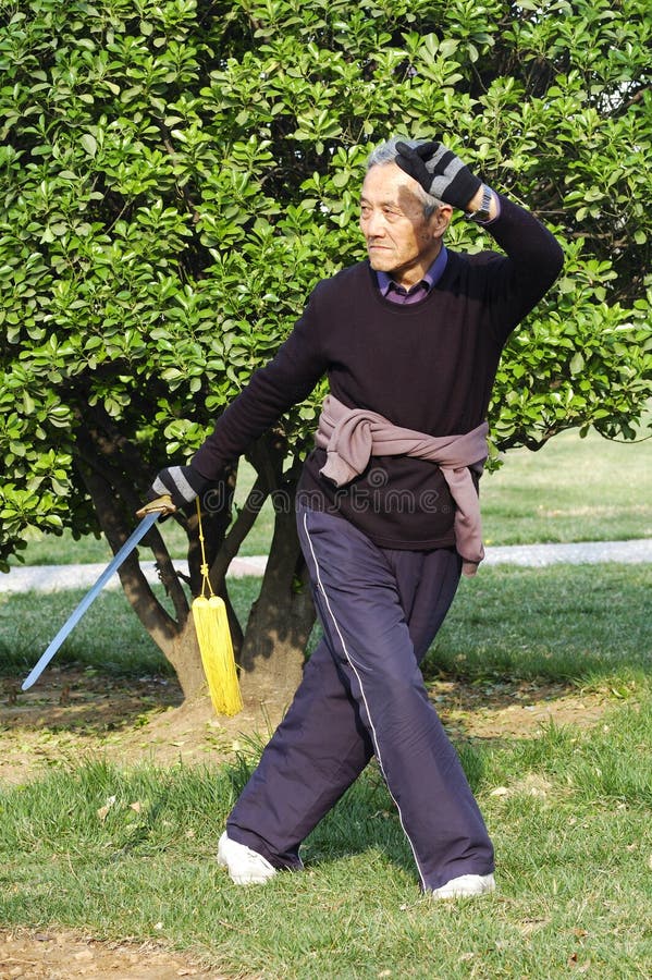 Viejo chino hombre jugar un poco de tradicional chino espada(espada) en manana.