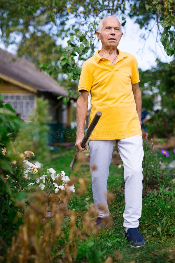 Senior Man with Shovel Standing in Yard of His House Stock Image