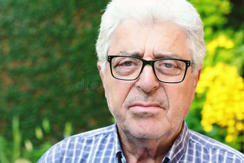 An old man sitting outside. stock photos