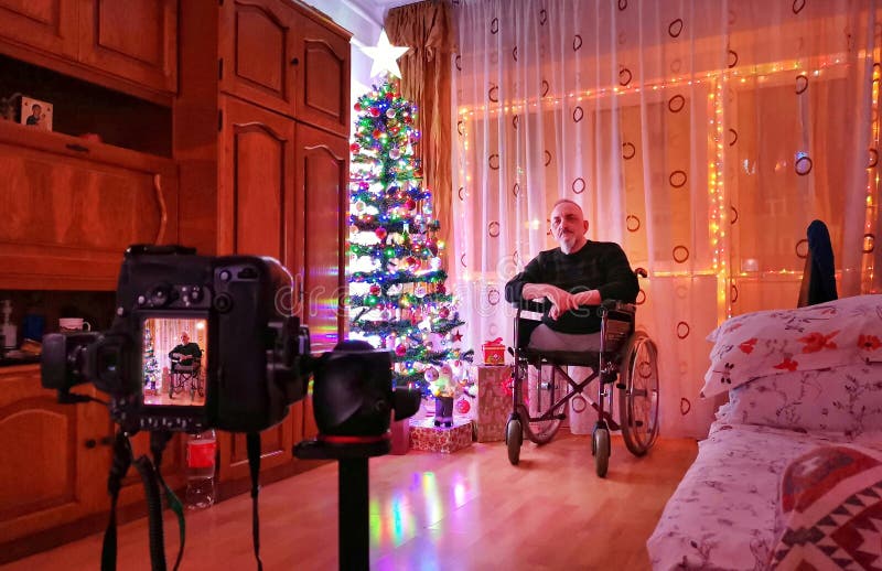 Old man in a wheelchair caught during a photo shoot on Christmas night