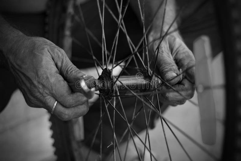 Starý muž pracovné na motocykel pneumatika nástroje blízko v služba obchod prst v ruky.
