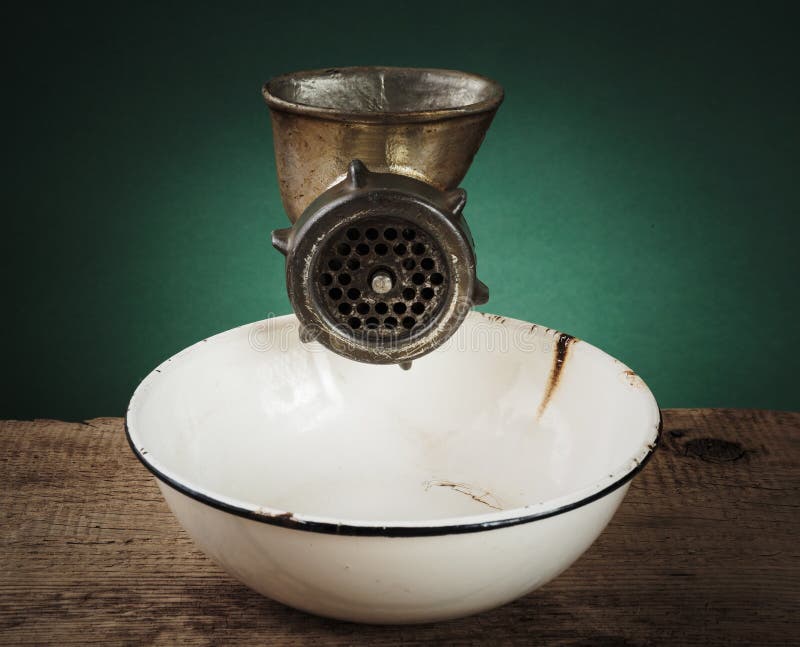 Old meat grinder and a white enamel bowl