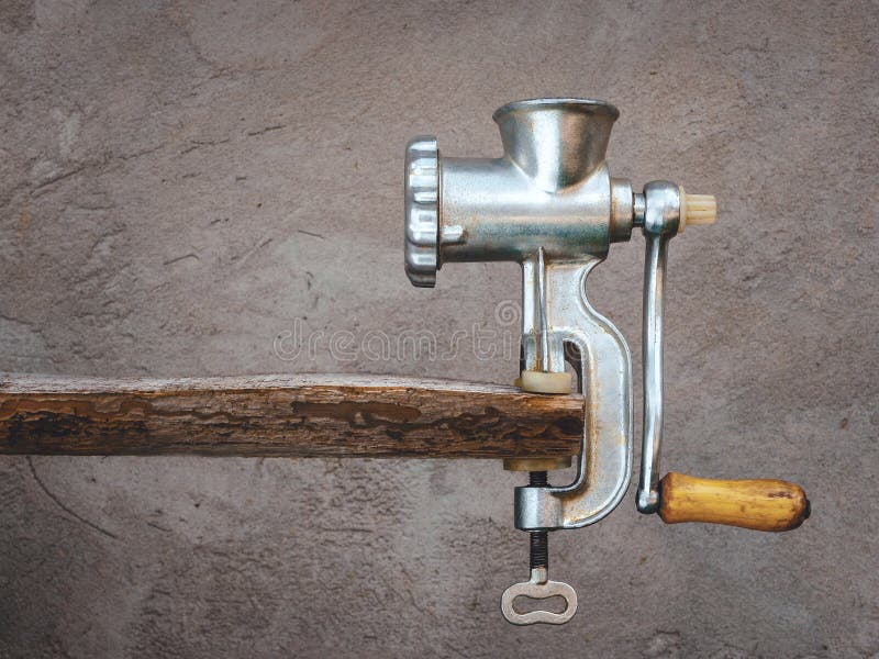 Old meat grinder on a wooden board