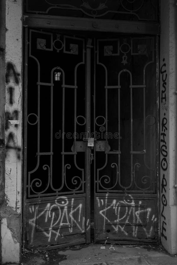 An old metal door with graffiti on it in grayscale - vertical shot. Retro grayscale paint stock images, royalty-free photos and pictures