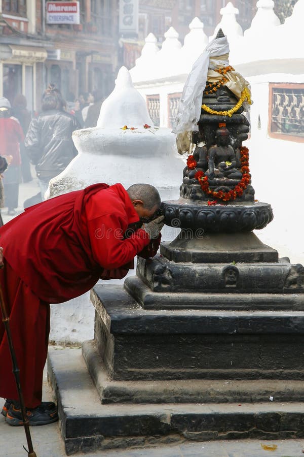 Old monk praying at a statue in Boudnath