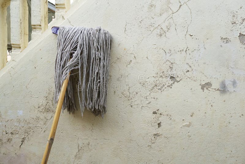Old mop on cement wall stock image. Image of cement 115504425