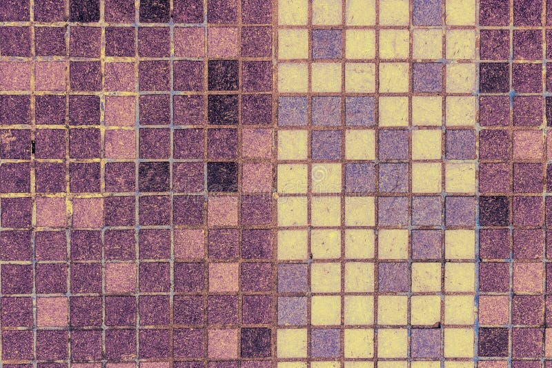 Old mosaic tiles of different colors lined verticaly