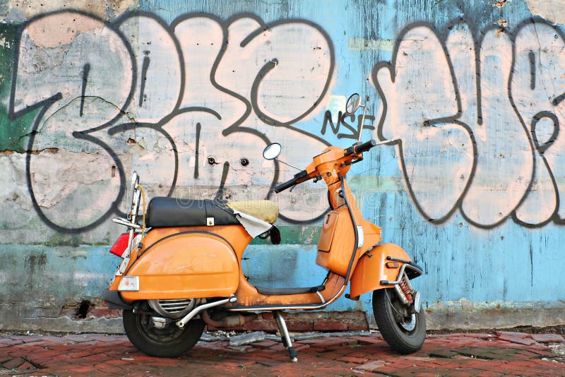 Old motorbike in front of graffiti wall