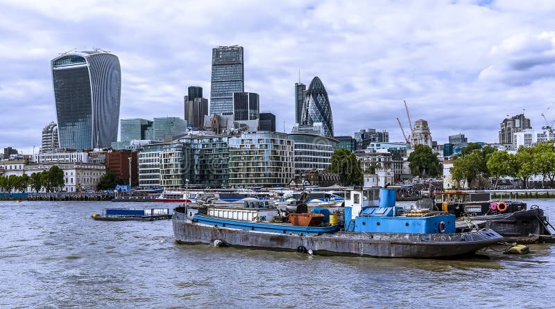 Old and new aspects of London with Thames barges in the foreground and the City of London in the background