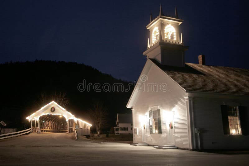 Old new england covered bridge with church at night