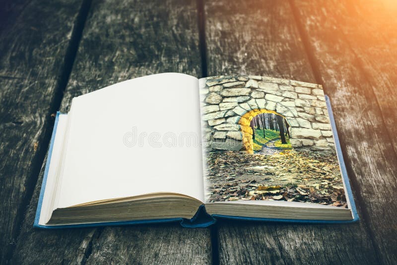 Old open book on a wooden table. Vintage composition. Ancient library. Antique literature. Medieval and mystical background. stock photo