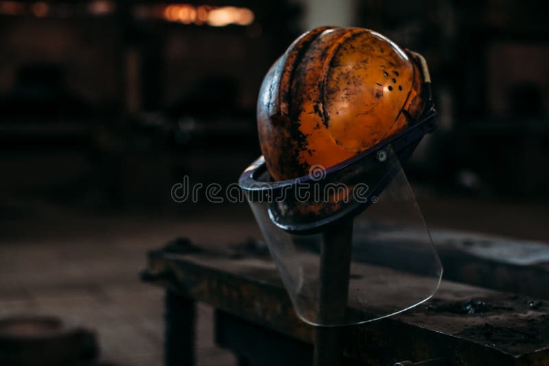 Old orange construction helmet on a factory, put on a stick stock images Old orange construction helmet on a factory, put on a stick stock images