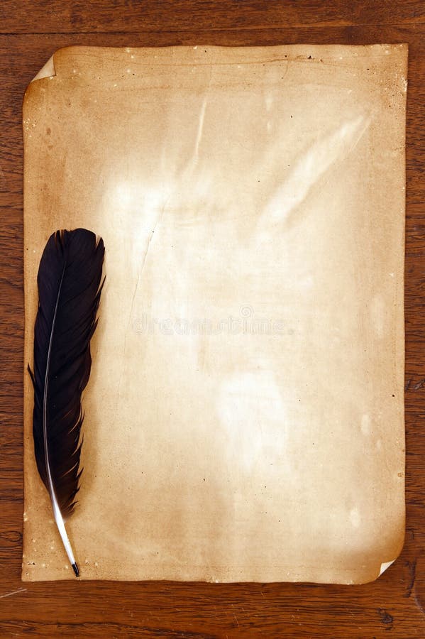 Old paper with feather on brown wood texture