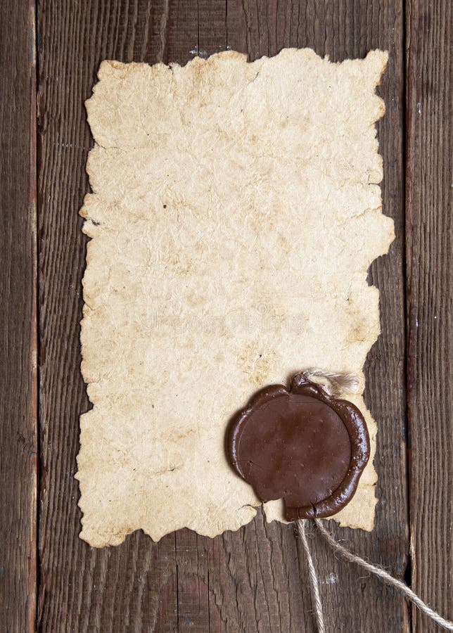 Old paper with a wax seal on brown wood texture