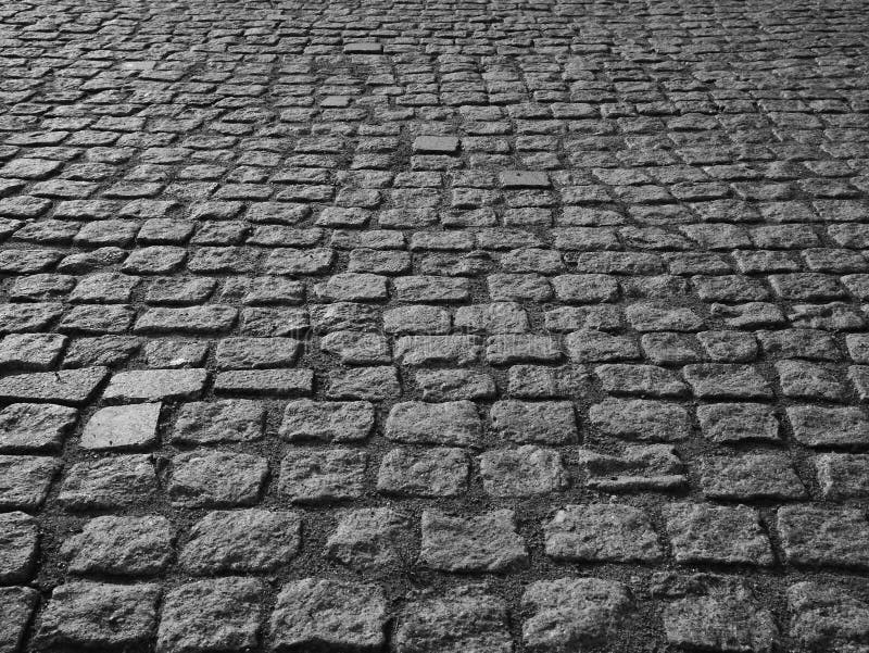 Old paving stones in perspective closeup. Black and white background.