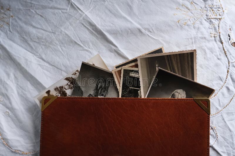 Old photo albums lie on white mint tablecloth, vintage photographs, concept of family tree, genealogy, childhood memories