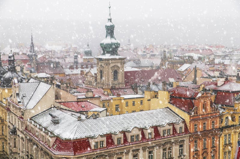 Old Prague architecture and red roofs view from above in winter snowfall