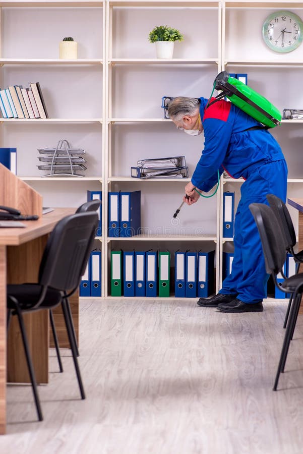 Old Professional Contractor Doing Pest Control in the Office Stock