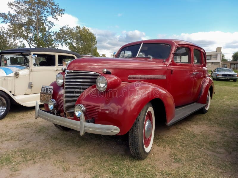 Old red 1939 Chevrolet Chevy Master sedan four door by General Motors on the lawn. Nature, grass, trees. CAACMACH 2023 classic car show. Old red 1939 Chevrolet Chevy Master sedan four door by General Motors on the lawn. Nature, grass, trees. CAACMACH 2023 classic car show.