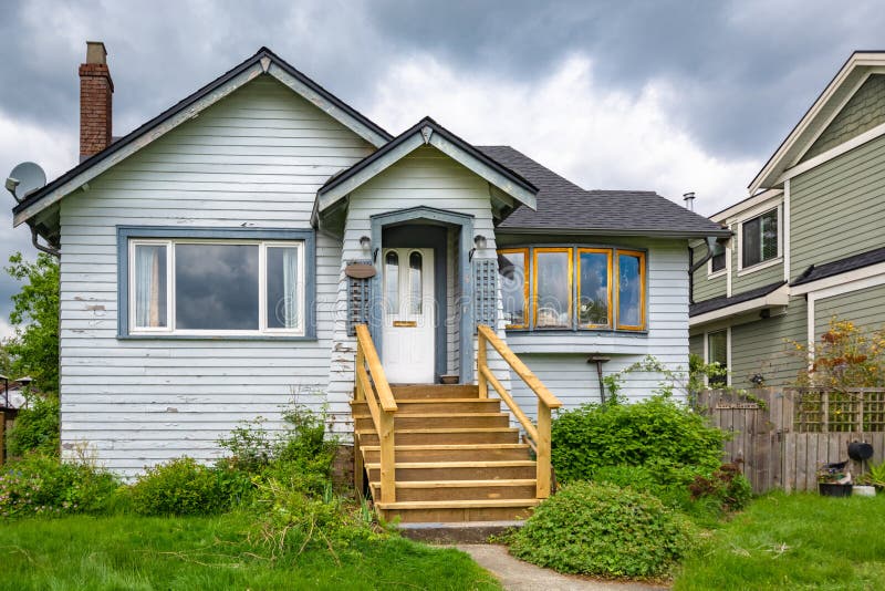 Old residential house with neglected lawn on the front yard.