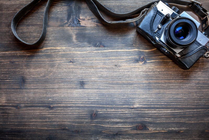 Old retro camera on wooden table background. Photography, film.