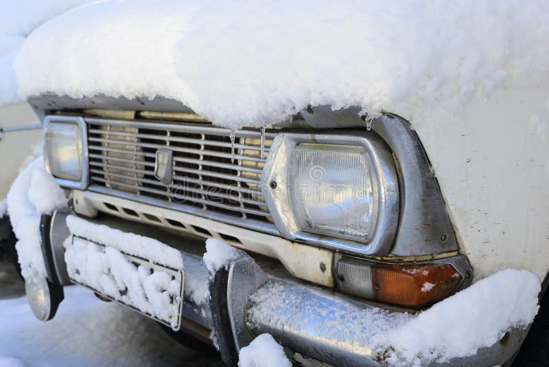 Old retro car under the snow detailed photo headlight with chrome grille and bumper stock image Old retro car under the snow detailed photo headlight with chrome grille and bumper stock image
