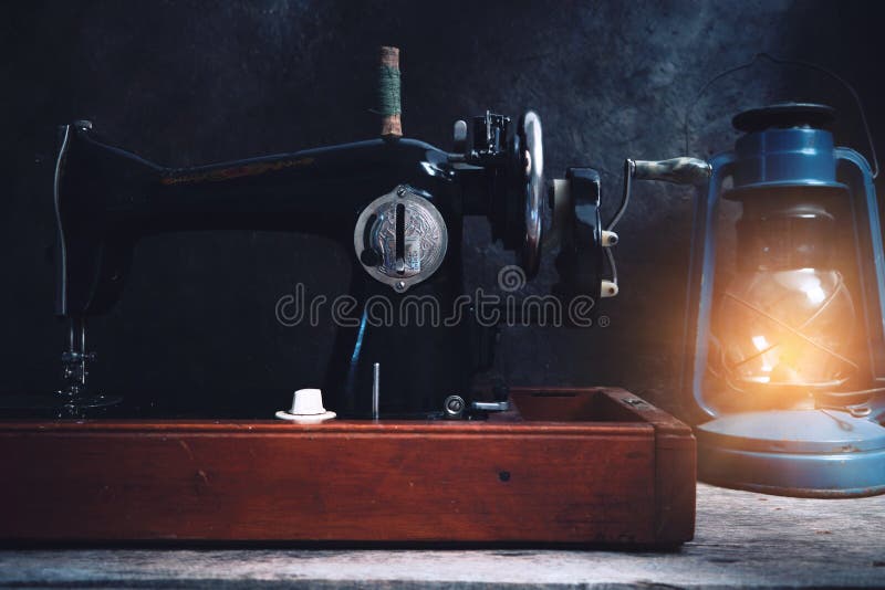 Old, Retro, Vintage Sewing Machine and a Kerosene Lamp on a Dark