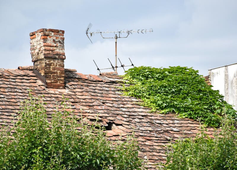 Old ruined roof of a house with antennas stock photos