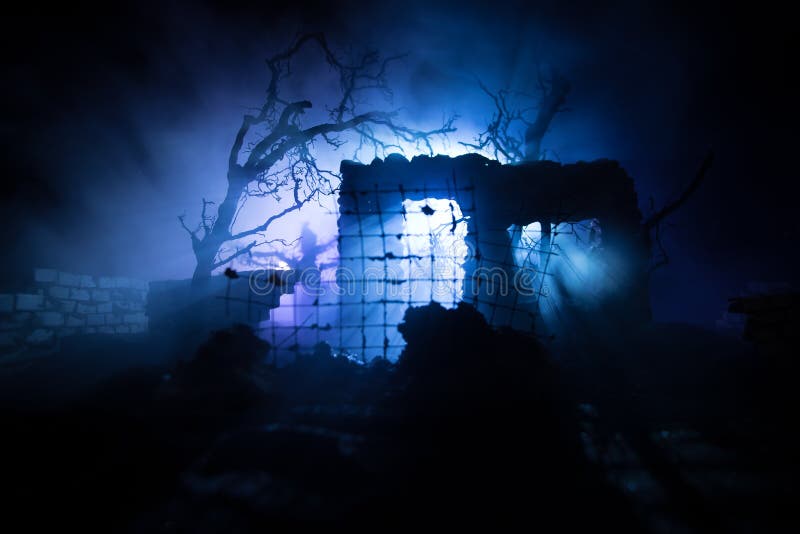 Old ruined stone house in deserted garden at night. Selective focus