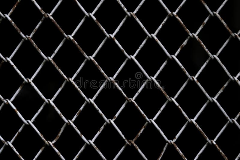 Old rust chain link fence metal wire mesh panel. Black background