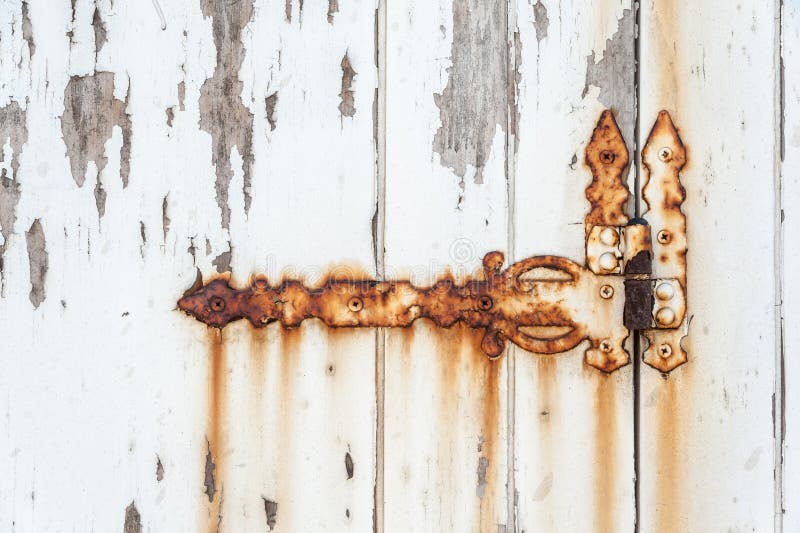 Old rusted hinge on a white door