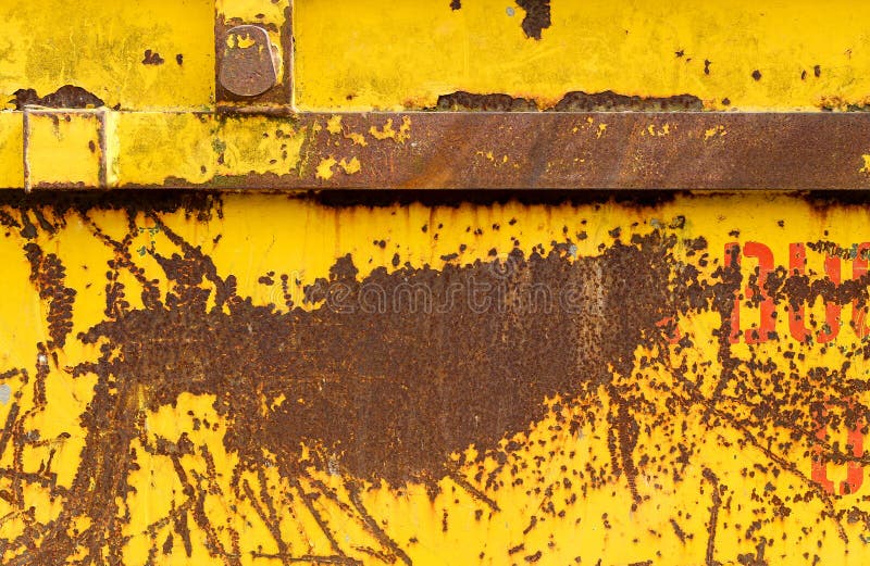 Old rusting metal skip container with yellow pealing paint