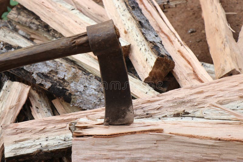 Old and Rusty Axe with Wooden Handle Stuck on Piece of Wood. Axe for