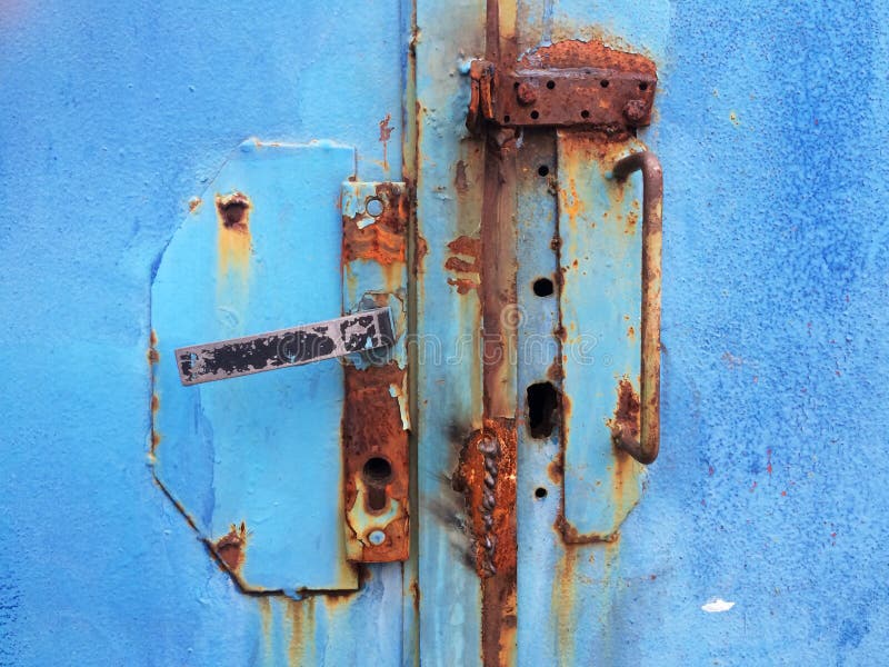 Viejo oxidado puerta la manija sobre el azul pintar agrietado puerta.