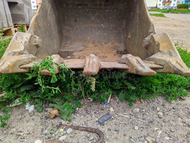 Old and Rusty Dirty Digger Excavator Bucket on the Street. Stock Image
