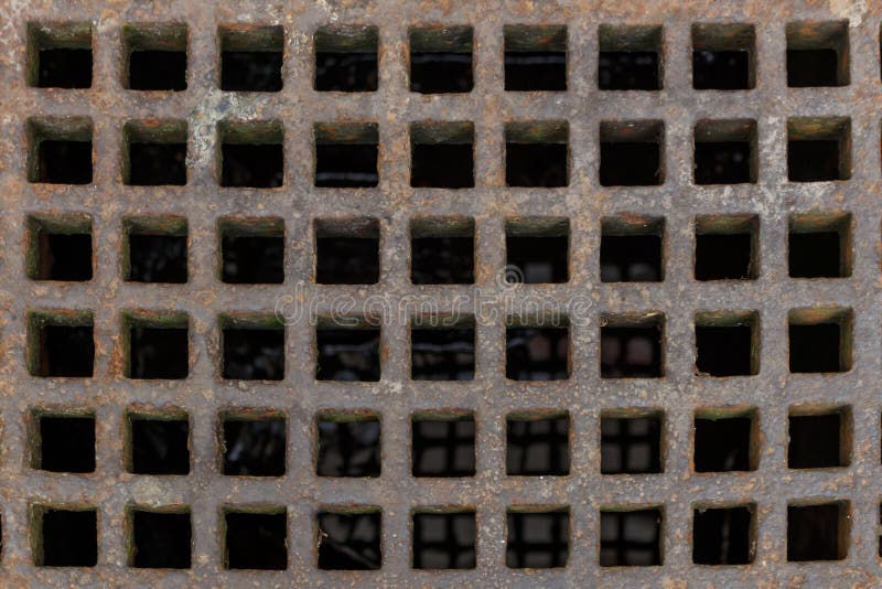 Old rusty iron street water sewer grate closeup top view