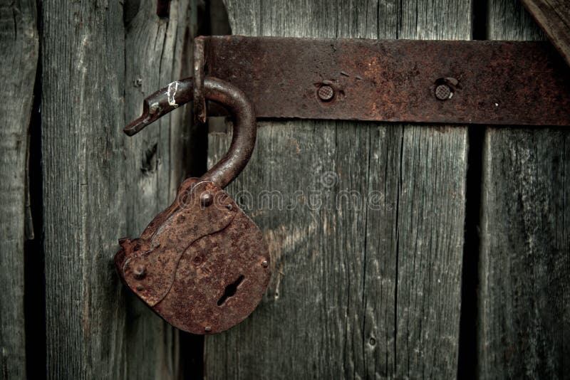 Old rusty opened lock without key. Vintage wooden door, close up concept photo