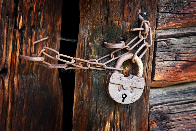 Old rusty padlock on rural wooden gate