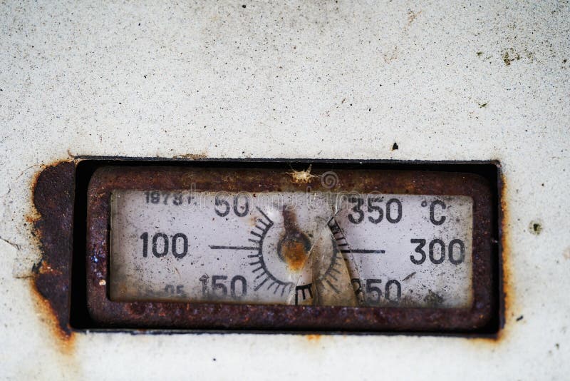 Old rusty thermometer with broken glass on the oven door stock images Old rusty thermometer with broken glass on the oven door stock images