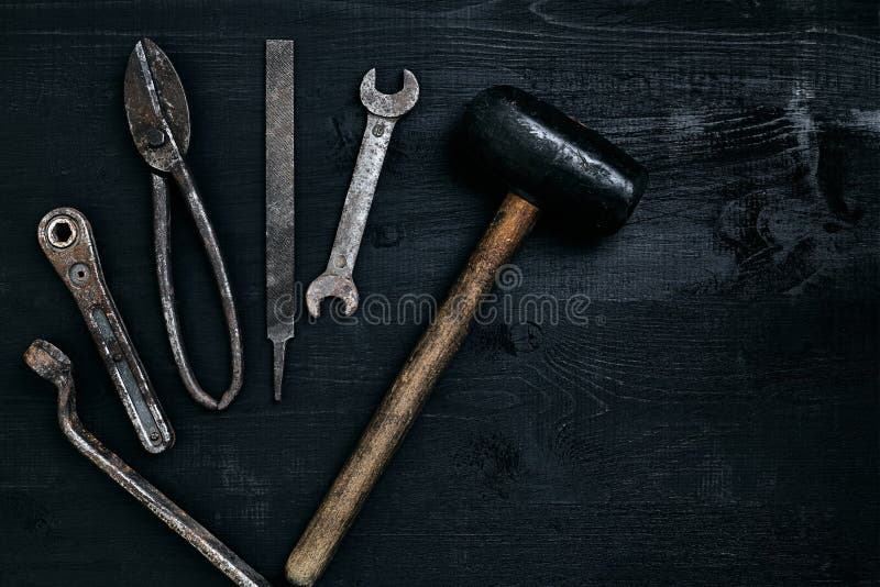 Old, rusty tools lying on a black wooden table. Hammer, chisel, metal scissors, wrench. royalty free stock photo Old, rusty tools lying on a black wooden table. Hammer, chisel, metal scissors, wrench. royalty free stock photo